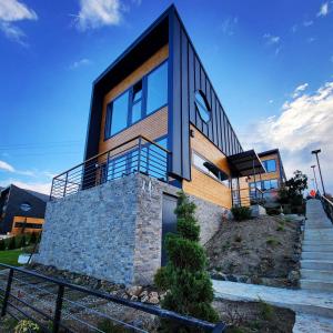 a modern house with glass windows and stairs at HUUT in Zlatibor