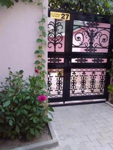 uma porta preta com um sinal e algumas flores em Стаи за гости Калина em Yambol