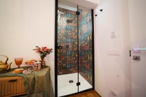 una ducha en una habitación con una mesa al lado en Casa Apuliae Bed & breakfast, en Bitonto