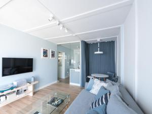 uma sala de estar com um sofá azul e uma televisão em WOW APARTMENT WITH PRIVATE JACUZZI and 2 terraces em Los Cristianos