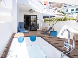 a balcony with a plunge pool and wooden deck at WOW APARTMENT with jacuzzi and terrace in Los Cristianos