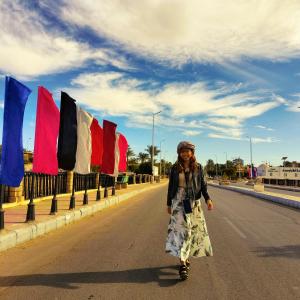 アブ・シンベルにあるSafari Abu Simbelの旗を掲げて歩く女