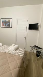 ein weißes Zimmer mit einem Bett und einer Tür in der Unterkunft MoMa B&B in Corigliano Calabro