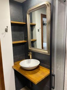 a bathroom with a sink and a mirror at Leyendas Del Pirineo in Fiscal