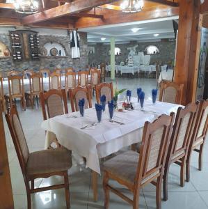 a long table with chairs and vases on it at Zezo Apartments in Bitola