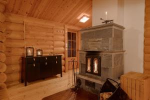 a living room with a stone fireplace in a log cabin at Villa Lappee in Kolari