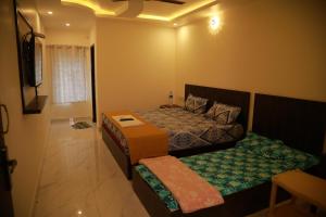 Dormitorio pequeño con cama y TV en Heaven Resorts, en Yercaud