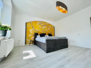 1 dormitorio con 1 cama grande y pared amarilla en Traumhaftes Meißen-Terrasse mit Burg-und Elbblick, en Meißen