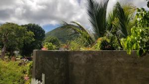 a concrete fence with a mountain in the background at Pierre's Place Grand-Case in Grand Case