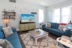 a living room with blue couches and a tv at Havin A Blas by Pristine Properties Vacation Rentals in Cape San Blas