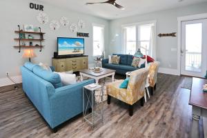 a living room with two blue couches and a tv at Havin A Blas by Pristine Properties Vacation Rentals in Cape San Blas