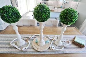 two white vases on a table with plants in them at Havin A Blas by Pristine Properties Vacation Rentals in Cape San Blas