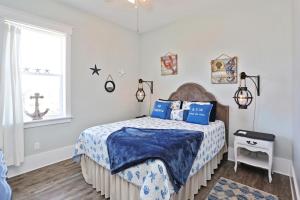 a bedroom with a bed with a blue comforter and a window at Havin A Blas by Pristine Properties Vacation Rentals in Cape San Blas