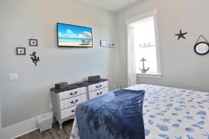a bedroom with a bed and a dresser and a window at Havin A Blas by Pristine Properties Vacation Rentals in Cape San Blas