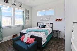 a small bedroom with a bed and a blue chair at Havin A Blas by Pristine Properties Vacation Rentals in Cape San Blas