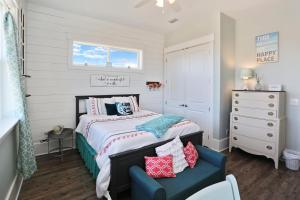 a small bedroom with a bed and a blue chair at Havin A Blas by Pristine Properties Vacation Rentals in Cape San Blas