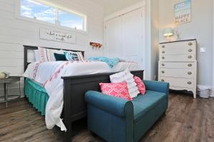 a bedroom with a bed and a blue chair at Havin A Blas by Pristine Properties Vacation Rentals in Cape San Blas