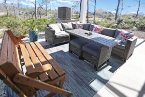 a patio with a couch and a table and chairs at Havin A Blas by Pristine Properties Vacation Rentals in Cape San Blas