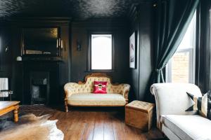 a living room with a chair with a pink pillow at House with a cinema and games room, sleeps 17 in Shrewsbury