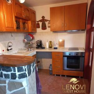 kuchnia z drewnianymi szafkami i piekarnikiem w obiekcie Къща за гости Ленови w mieście Elena