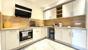 a white kitchen with white cabinets and a microwave at Studio Apartment - nahe Itzehoe in Itzehoe