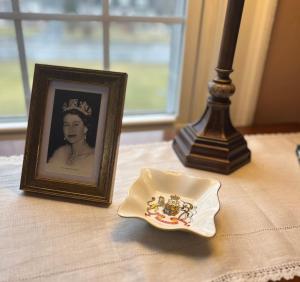 une photo d'une reine et d'une plaque sur une table dans l'établissement Antique1242 British Bed & Breakfast, à Enfield