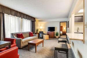 a living room with a couch and a table at Best Western Chicago - Downers Grove in Downers Grove