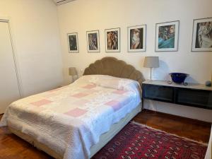 a bedroom with a bed and a table and pictures on the wall at VILLA TARA in Quercianella
