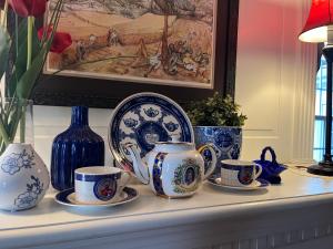 a shelf with blue and white cups and plates on it at Antique1242 British Bed & Breakfast in Enfield