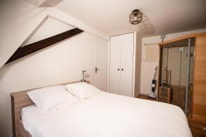 ein Schlafzimmer mit einem weißen Bett in einem Zimmer in der Unterkunft Moderne T2 Centre Sauna Wifi Home office Netflix in Straßburg