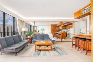 ein Wohnzimmer mit einem Sofa und einem Tisch in der Unterkunft Beautiful Renovated Mountain View Condo with Parking! in Honolulu