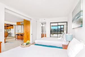1 Schlafzimmer mit einem weißen Bett und einer Küche in der Unterkunft Beautiful Renovated Mountain View Condo with Parking! in Honolulu