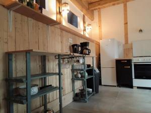una cocina con paredes de madera y estanterías en una habitación en Loft les Noies Parrons, gîte aux milles étangs en Mélisey