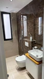 a bathroom with a toilet and a sink at Entire holiday flat in Sarande in Sarandë