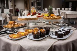 a table with various pastries and cakes on plates at Les Petites Maisons in Montevarchi
