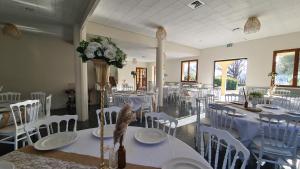a dining room with white tables and white chairs at Angeprovence in Saint-Étienne-les-Orgues