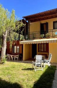 due sedie e un tavolo di fronte a una casa di Casa Vacanze Il Salice IUN R6393 a Flumini di Quartu