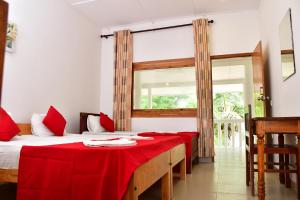 a room with a bed with a red blanket on it at Sea Way Hotel in Nilaveli +45 photos