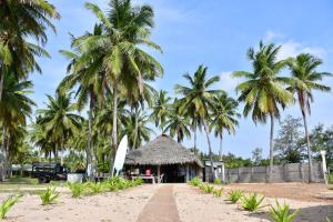 una capanna sulla spiaggia con palme di Sea Way Hotel a Nilaveli