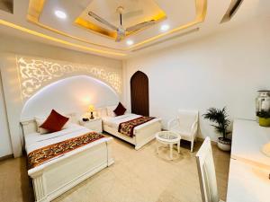 Habitación de hotel con 2 camas y mesa en Hotel Lavish Inn Rajouri Garden Couple Friendly, New Delhi en Nueva Delhi