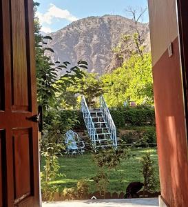 une porte ouverte donnant sur une cour avec vue sur la montagne dans l'établissement Chitral Green Guest House, à Chitral
