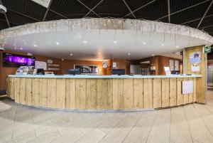a restaurant with a large wooden counter in a building at Résidence Les Temples du Soleil - maeva Home - Studio 4 Personnes Confort 43 in Val Thorens