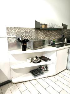 a white kitchen with a sink and a counter at Tranquil Living on Maboneng in Johannesburg