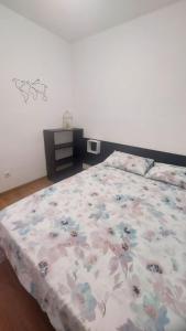1 dormitorio con 1 cama con edredón de flores en Mar & Aventura, en Torredembarra