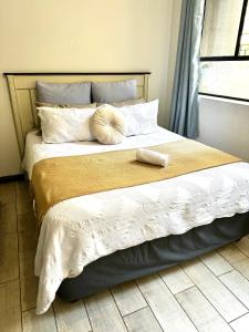 una camera da letto con un grande letto con un cuscino sopra di Tranquil Living on Maboneng a Johannesburg