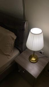 a lamp on a wooden table next to a bed at شقه بصالة انيقة وغرفة نوم . in Al Khobar