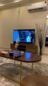 a living room with a tv and a coffee table at شقه بصالة انيقة وغرفة نوم . in Al Khobar
