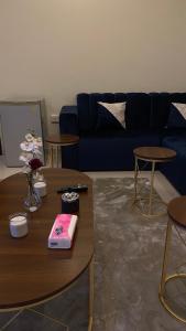a living room with a blue couch and tables at شقه بصالة انيقة وغرفة نوم . in Al Khobar