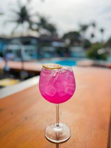 a pink drink in a wine glass on a table at Poozendin Hotel de Charme in Canoa Quebrada
