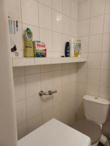 a bathroom with a toilet and shelves on the wall at Однокімнатна квартира Варшава in Warsaw